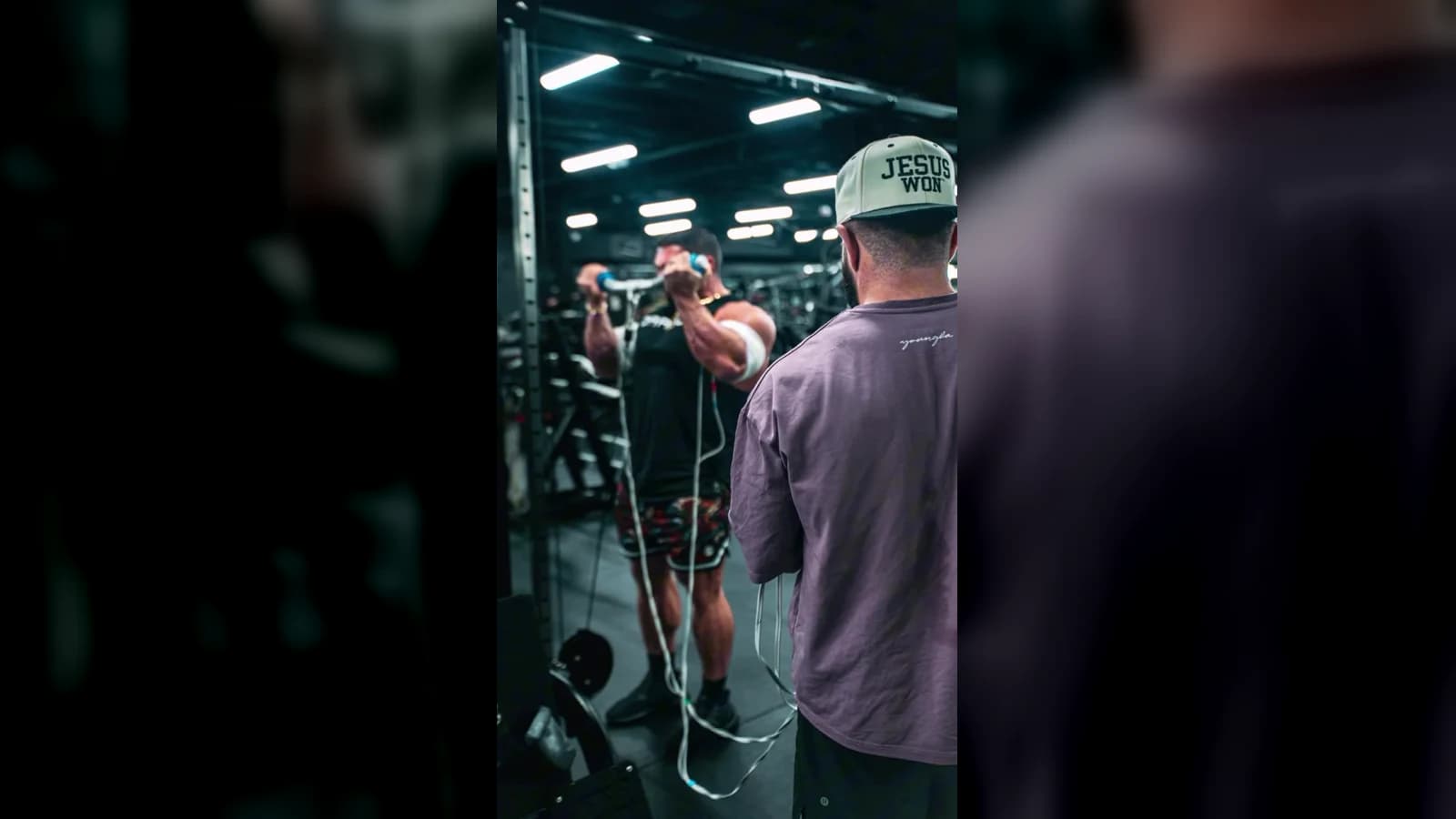 Jason coaching an active electrical-stimulation curl session on the bodybuilding gym floor