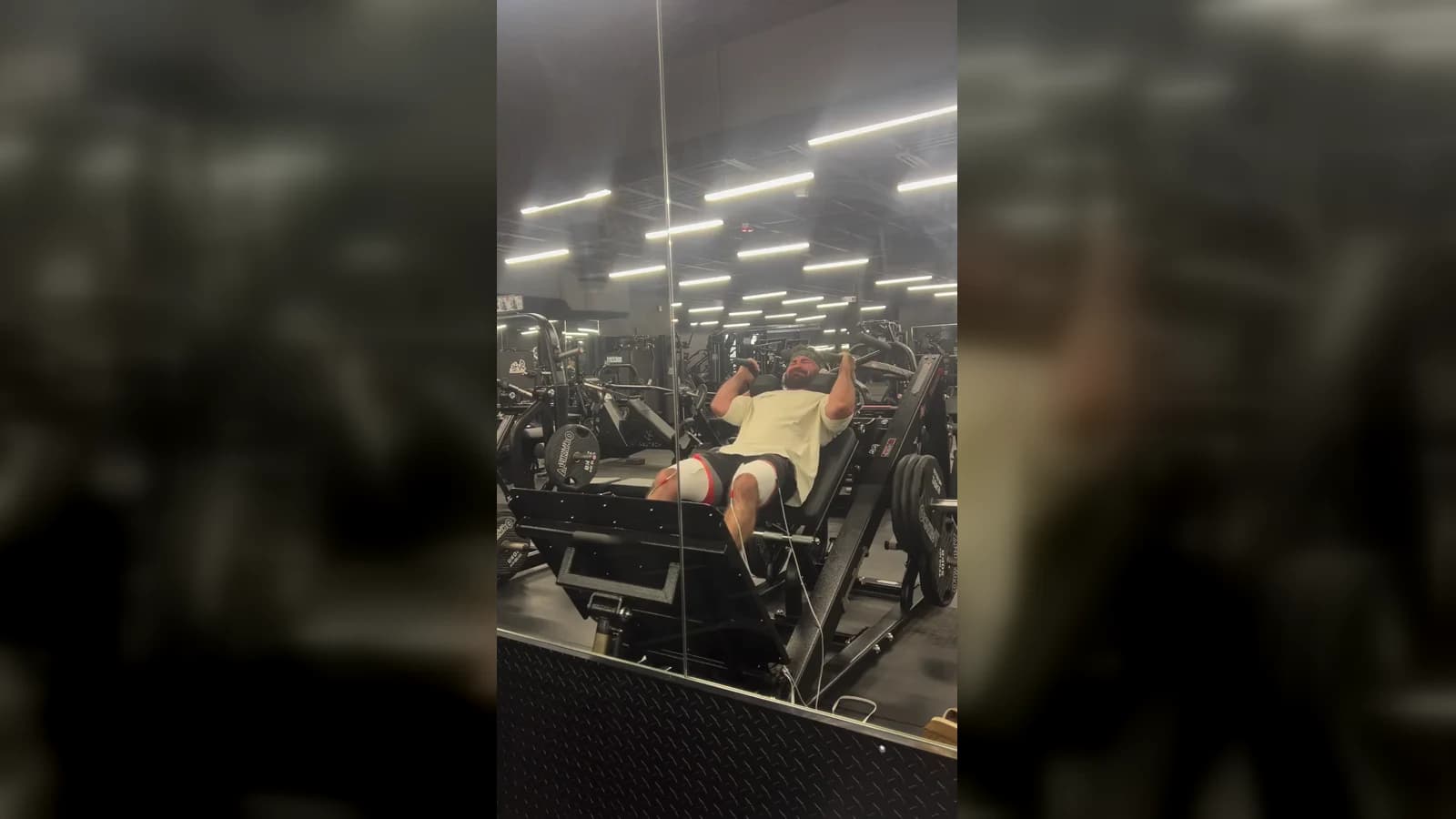 A bodybuilder completing an electrically stimulated leg-press session in the gym