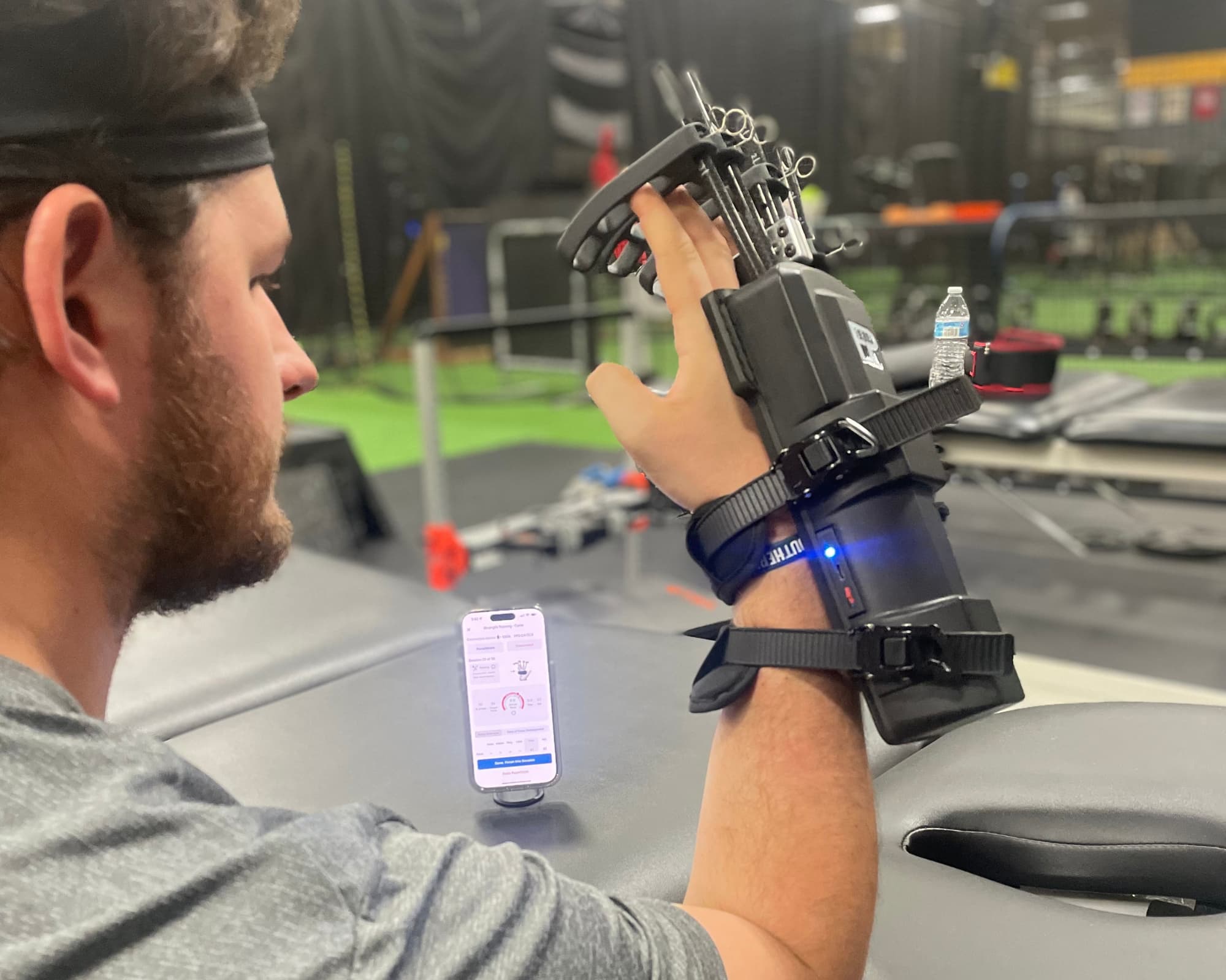 A baseball athlete completing objective hand and forearm strength testing during elbow rehabilitation