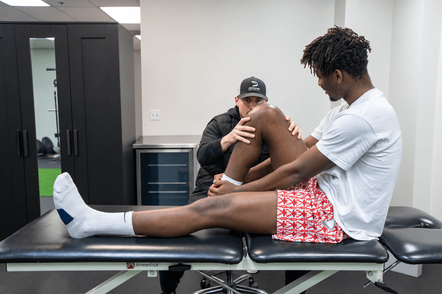 Physical therapist assessing an athlete during a one-on-one rehabilitation session