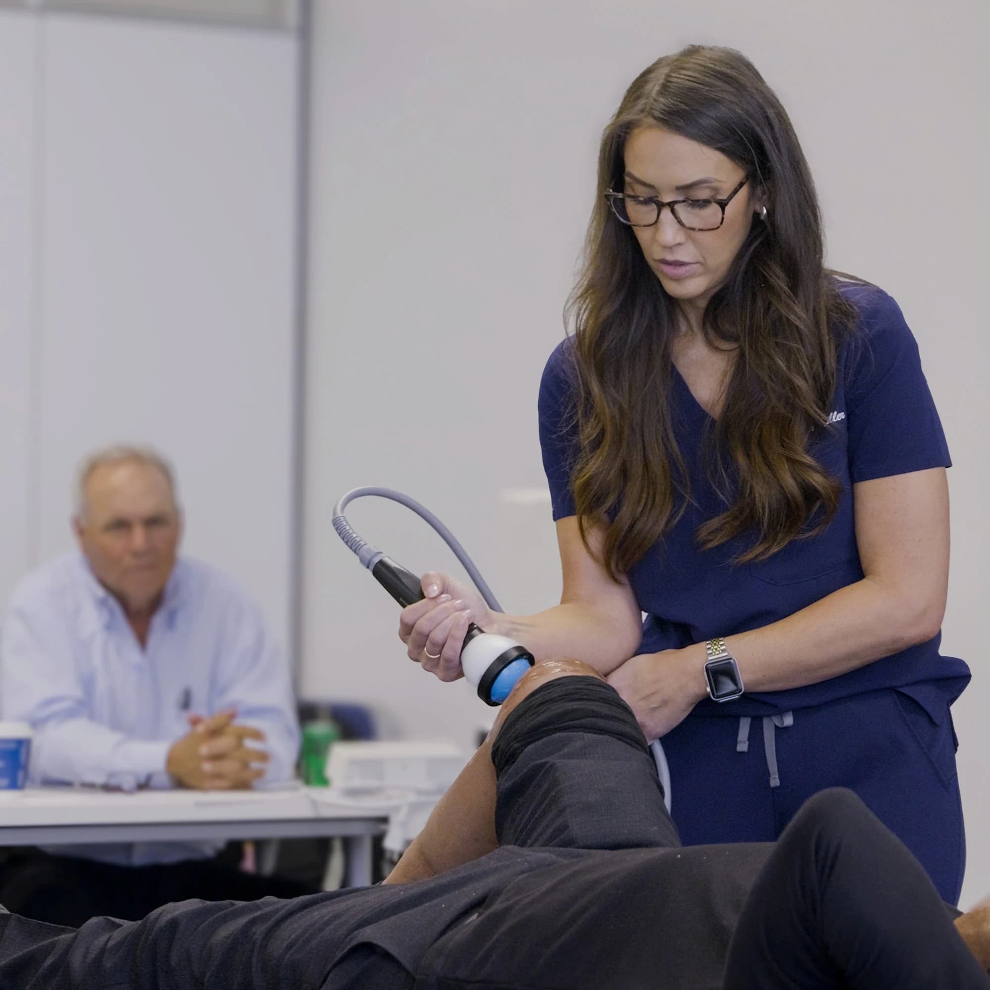 Clinician applying StemWave treatment near the knee